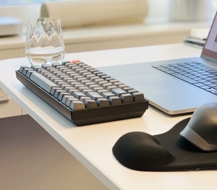 Picture of a TypeMaster Keyboard next to a glass of water